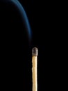 Faded matchstick with white rising smoke isolated on a black