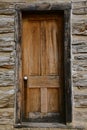 Faded oak door of a weathered old log cabin with chinking. Royalty Free Stock Photo
