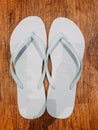 faded pale blue flip-flops on the wooden floor