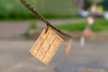 A faded square piece of linoleum hanging from a boundary chain