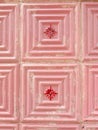 Faded textured tiles of pink colours with scratches. Vintage tile work with geometrical ornate. Antique flooring. Vertical photo