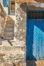 Faded and weathered white wall and stairs, blue painted door, Greece. Traditional architecture, details, authentic Royalty Free Stock Photo