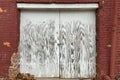 Faded white painted locked shipping receiving dock doors red brick warehouse Royalty Free Stock Photo