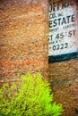 Fading ad fragment on a red brick wall Royalty Free Stock Photo
