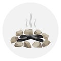 A fading bonfire surrounded by stones. Smoke on the fire, ashes