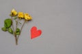 Fading love concept. Three dried roses and a red heart symbol ag Royalty Free Stock Photo