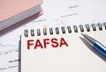 FAFSA text written on notepad with pen on financial documents Royalty Free Stock Photo