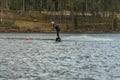 Wakeboarder surfing across a lake in spring in Sweden