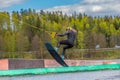 Wakeboarding. Teen Wakeboarder makes extremely difficult jump in air on wakeboard. Girl flies in the sky Royalty Free Stock Photo