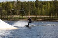 Young wakeboarder rides a wakeboard on the lake. Wakeboarding is cool, extreme sport