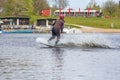 Young wakeboarder rides a wakeboard on the lake. Wakeboarding is cool, extreme sport Royalty Free Stock Photo