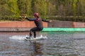 Young wakeboarder rides a wakeboard on the lake. Wakeboarding is cool, extreme sport Royalty Free Stock Photo