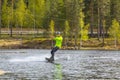 Young wakeboarder rides a wakeboard on the lake. Wakeboarding is cool, extreme sport Royalty Free Stock Photo