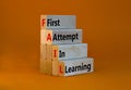 FAIL first attempt in learning symbol. Wooden blocks with words FAIL first attempt in learning. Beautiful orange table, orange Royalty Free Stock Photo