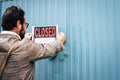 Failed business man store owner with closed signs on the door of his shop - coronavirus lockdown economy emergency crisis concept Royalty Free Stock Photo