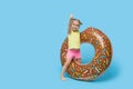 Failed summer vacation. Happy surprised child model girl resting on a donut-shaped rubber ring.