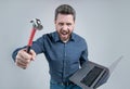 Failed to complete a task. Angry man shout holding hammer and laptop. Computer rage. Feeling angry