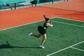 Failing teenage girl playing tennis on a new court, missing on a fast ball