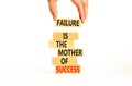 Failure or success symbol. Wooden blocks with words A failure is the mother of success. Beautiful white table white background.