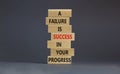 Failure or success symbol. Wooden blocks with words A failure is success in your progress. Beautiful grey background, copy space.