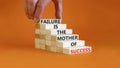 Failure or success symbol. Wooden blocks with words A failure is the mother of success. Beautiful orange table orange background.