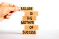 Failure or success symbol. Wooden blocks with words A failure is the mother of success. Beautiful white table white background. Royalty Free Stock Photo