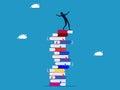 Failure to learn. man stands lost on a high stack of collapsing books