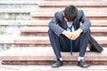 Failure unemployed stressed young Asian business man in suit. A young businessman sitting desperate on the stairs because low