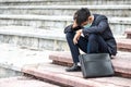 Failure unemployed stressed young Asian business man in suit covering head with hands. A young businessman sitting desperate on Royalty Free Stock Photo