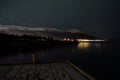 Faint aurora borealis on night sky over mountain and sea