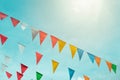 Fair flag bunting colorful background hanging on blue sky for fun fiesta party event, summer holiday farm feast celebration