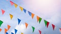 Fair flag bunting colorful background hanging on blue sky for fun fiesta party event, summer holiday farm feast celebration