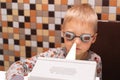 A fair-haired boy in pajamas undergoes prevention of viruses and diseases at home using a quartz germicidal irradiator. Disease Royalty Free Stock Photo