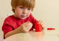 fair-haired child sculpts with red plasticine. children's entertainment, leisure, activities, educational games