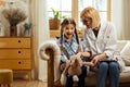 Fair-haired pediatrician giving a girl a stethoscope to try on