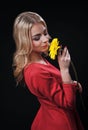 The fair-haired young girl woman on a black background with a bouquet branch of yellow chrysanthemums in hands Royalty Free Stock Photo