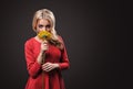 The fair-haired young girl woman on a black background with a bouquet branch of yellow chrysanthemums in hands Royalty Free Stock Photo