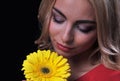 The fair-haired young girl woman on a black background with a bouquet branch of yellow chrysanthemums in hands Royalty Free Stock Photo