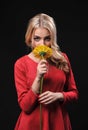 The fair-haired young girl woman on a black background with a bouquet branch of yellow chrysanthemums in hands Royalty Free Stock Photo