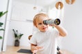 Little boy looking into kaleidoscope. Blurred. Focus on a boy. At home Royalty Free Stock Photo