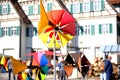 Fair at the market square in the city center, artisans sell self-made goods, shoppers stroll through the sunny city, windmills and