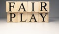 Fair play word from wooden cubes. Spotlight and white background