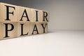 Fair play word from wooden cubes. Spotlight and white background