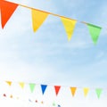 Fair ribbon made of multicolored triangles against the sky