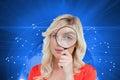 Fairhaired woman looking through a magnifying glass Royalty Free Stock Photo