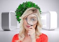 Fairhaired woman looking through a magnifying glass