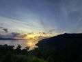 fairly cloudy sunset reflected on water behind the hill side lake Royalty Free Stock Photo