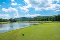 Fairway on green grass with cloudy blue sky and lake Royalty Free Stock Photo