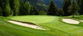 Fairway, sand traps, and green nestled into an alpine woodland, golf course background