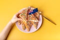 Fairy bread in hand. The famous traditional Australian food Fairy Bread on a yellow background